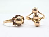 two gold rings, one with a ball and the other with a flower