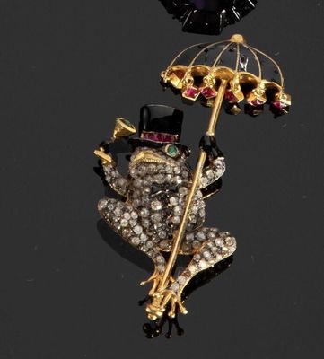 une broche représentant une grenouille avec un haut-de-forme et un parapluie