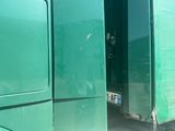 a green truck that is parked in the street