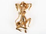 an image of a gold plated brooch depicting a woman playing a violin