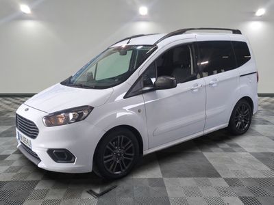 la camionnette blanche est garée sur le sol en damier d'un garage