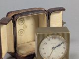 une petite horloge posée dans un coffret sur une table