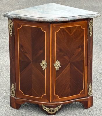 une petite armoire en bois avec un plateau en marbre, posée dans la rue