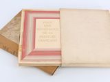 trois livres sont empilés sur une surface blanche