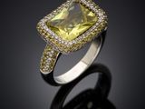 a close up of a yellow and white diamond ring on a black surface