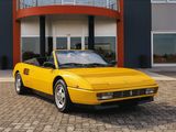 yellow sports car parked in front of a building with a balcony