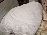 a bed with a white comforter on top of it in a room