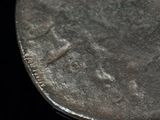 a close up of a silver coin with a knife sticking out of it