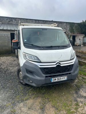 Une camionnette blanche est garée devant un immeuble.