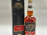 une bouteille de rhum Plantation devant une boîte