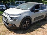 La voiture est garée dans l'herbe, à côté d'autres voitures.