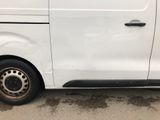 a white van with a flat tire parked in a parking lot
