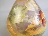 une image représentant un vase orné de feuilles et de fleurs