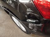 a car that has been dented and has been painted black