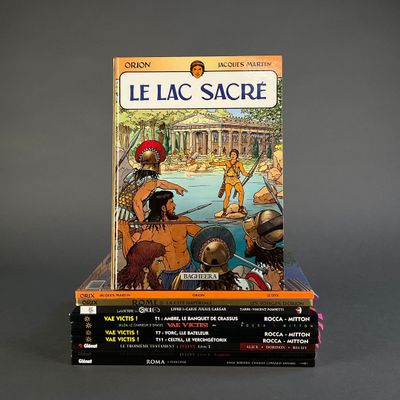 several books are stacked on top of each other on a gray surface