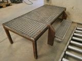 une table en métal sur laquelle est posé un banc, dans une pièce