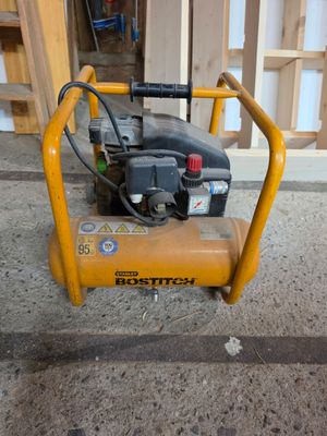 un petit compresseur d'air posé par terre devant un bâtiment