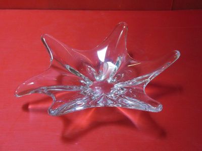 une fleur en verre transparent posée sur un fond rouge