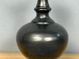 un vase noir posé sur une table en bois
