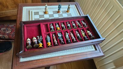 une boîte en bois contenant des pièces d'échecs, posée sur une table