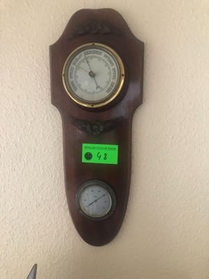 une horloge accrochée au mur, sur laquelle est collé un autocollant vert