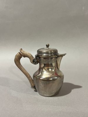 une cafetière ancienne en métal argenté, munie d'une poignée en bois
