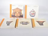three books on a white table with a picture of a teapot and a vase