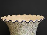 a vase that is sitting on a table with a black background