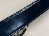 a close up of a black leather belt on a white surface