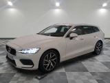 une Volvo break blanche garée sur un sol en carrelage à damier
