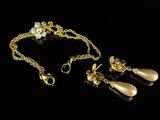 a gold necklace and earring set with pearls