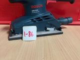 une ponceuse Black & Decker posée sur une table en bois