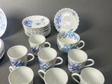 a lot of cups and saucers sitting on a table