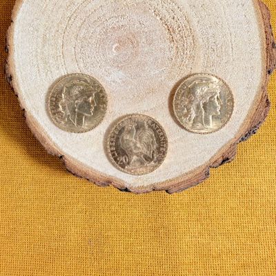 three coins sitting on top of a piece of wood