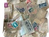 a pile of old postage stamps on a white surface