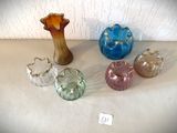 cinq vases en verre de couleurs différentes posés sur une table