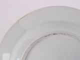 a white plate with a brown rim sitting on a table