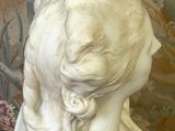 une statue représentant une femme aux longs cheveux, posée sur une table
