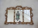 a mirror hanging on the wall above a chandelier