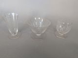 trois vases en verre posés l'un à côté de l'autre sur une table