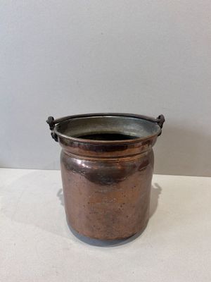 a small metal pot sitting on a white table