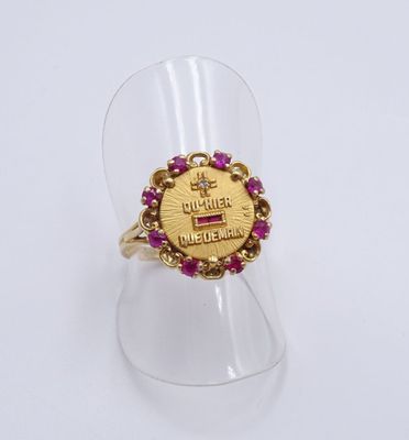 Gros plan sur une bague en or ornée de pierres roses