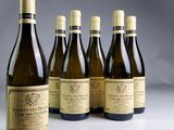 six bottles of wine are lined up on a table