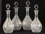 trois carafes en verre transparent avec des bouchons en cristal, sur fond noir