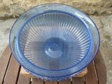 a blue glass bowl sitting on a wooden table