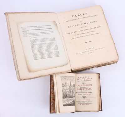 un livre ouvert posé sur une table à côté d'un livre