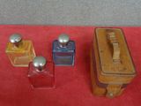 three small bottles of perfume on a red surface