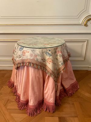 table with a pink table cloth on it sitting on top of a hard wood floor