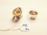 two gold rings and a tag with the word all a c written on them