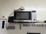 a microwave that is sitting on a shelf in a room